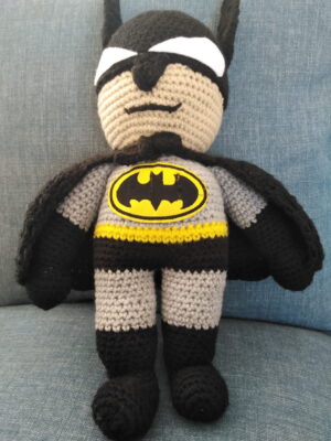 A 35cm crocheted Batman soft toy standing with arms at his sides and a stern expression on his face.